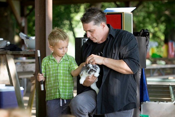 Magician Amazing Kevin showing a rabbit to a child.